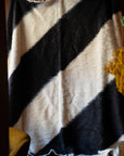 Marie Olsson Nylander hand-tufted Ukrainian wool blanket rug with wide diagonal black and cream graphic blockstripes resembling a traditional Lizhnyk throw.